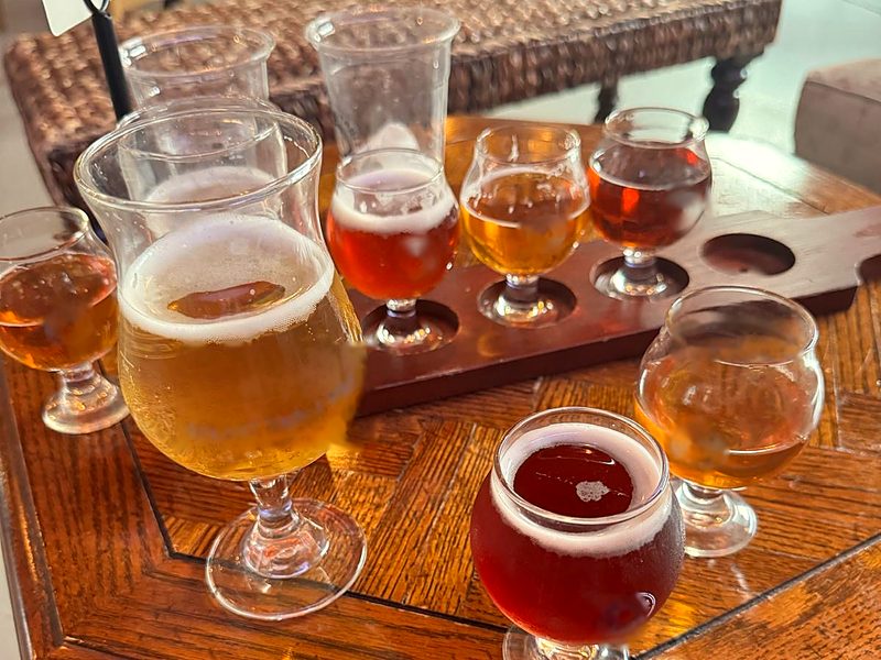Tasting flight of beers in different colors on a wooden table